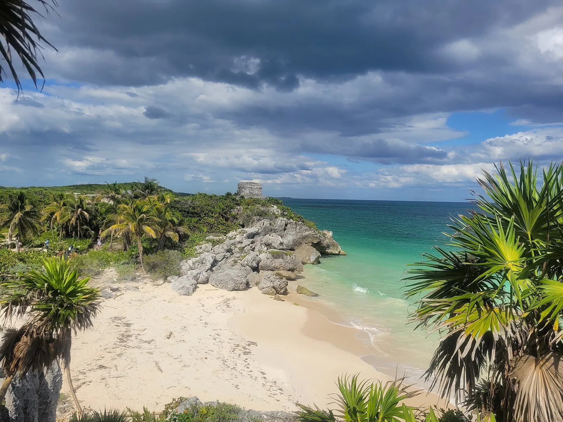 Playa de arena blanca entre rocas en Tulum